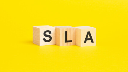 sla - text on wooden cubes, on yellow background. Service Level Agreement concept