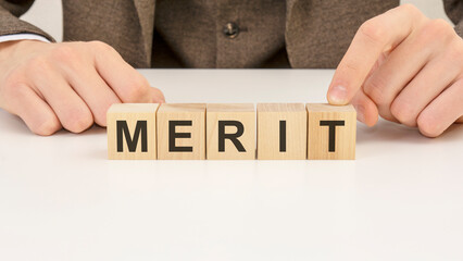 man made word merit with wooden blocks