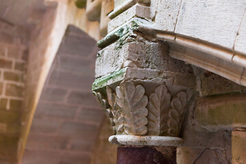 Closeup of details of decorative capital of porphyry column under stairs leading on royal residence in Monastery of Santa Maria de Santes Creus, Aiguamurcia, Spain..