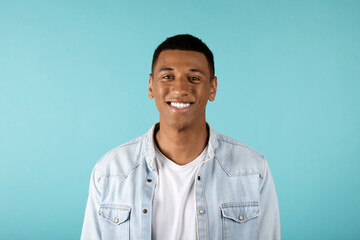 Portrait of happy attractive millennial african american guy in jeans look at camera
