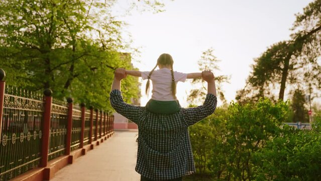 happy family sunset. father with child kid laugh merrily playing outside. cheerful father carries kid daughter his shoulders rays sun. dream childhood.joyful baby kid girl fun laughing father sun.