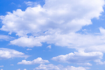 Clear blue sky with white fluffy clouds in summer day.