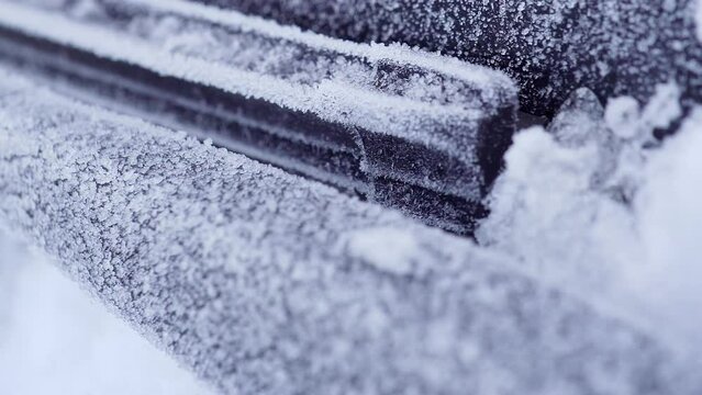 close up frozen automobile wipers on the icy glass