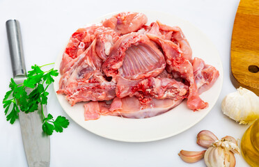Rabbit sliced with herbs in white plate prepared for cooking in restaurant
