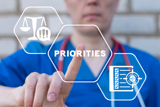Doctor using virtual touchscreen presses word: PRIORITIES. Time management healthcare priority. Medical and pharmacy priorities concept.