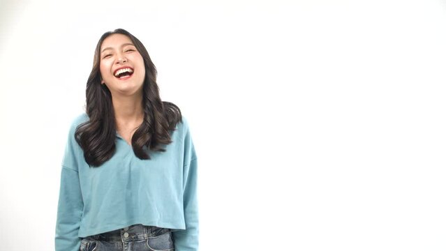 Cheerful Asian young woman laughing with healthy teeth emotion fun on white background. Beautiful happy model lady wearing blue casual smiling funny on face over isolated with copy space.