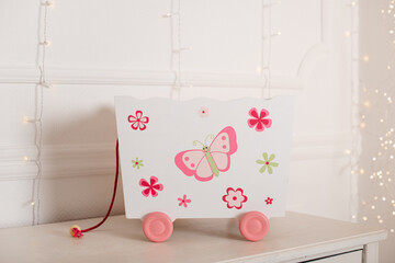 A delicate wall print featuring a pink butterfly and floral decorations in a soft pastel style.