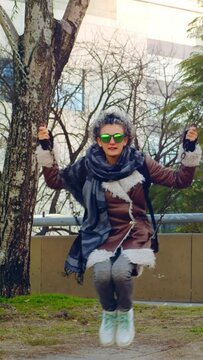 Mujer sentada en un colmpio relajadamente una tarde invernal	