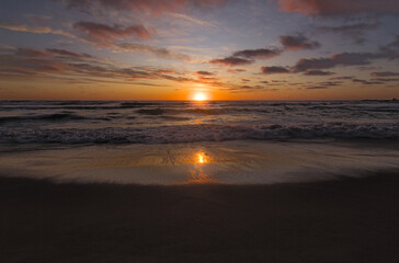 sol reflejandose en la espuma marina, puesta de sol