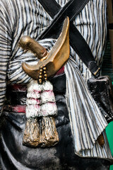 Rear view of a statue of a person dressed in Javanese traditional clothing.