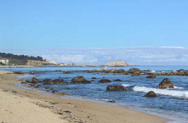 paisaje de la playa, olas rocas y pajaros junto con la arena del mar