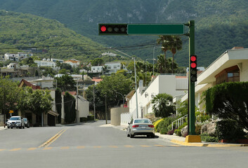 Cars on road near beautiful buildings in mountains. Traffic rules