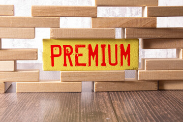 word premium made of small gray wooden letters on a green paper background