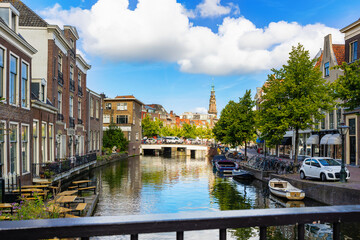 Fototapeta premium Streets along canal of Leiden with view of Heilige Lodewijkkerk. City in Province of South Holland, Netherlands.