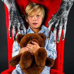 Frightened Child Sitting In Chair with Teddy Bear With Monster Hands Coming Over Him