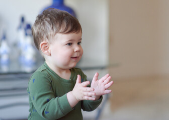 cute boy clapping his hands at home