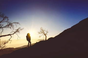 Silhouette of male hiker enjoying sunrise view