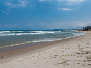 Barra da Tijuca beach, Rio de Janeiro, Brazil. Sunny day with blue sky and some clouds. Windsurfing practice