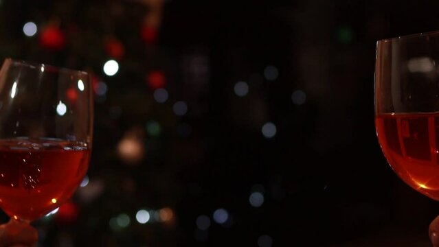 Brindis de sidra frente a un &aacute;rbol de navidad en desenfoque 