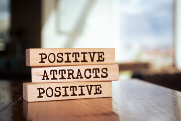 Wooden blocks with words 'Positive Attracts Positive'.