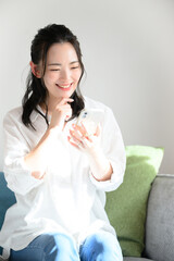 スマホを素敵な笑顔で持つかわいい女性　縦
