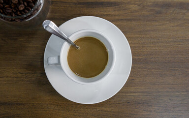 A cup of 3 in 1 instant coffee on wooden table. Top View