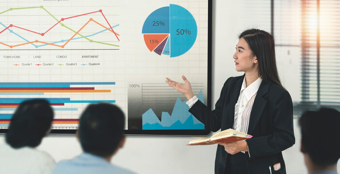 Young asian businesswoman presenting to her colleague in conference room with television screen presentation.