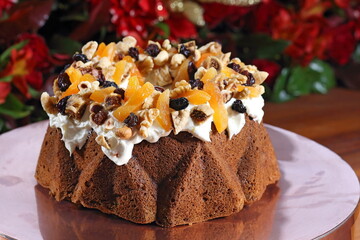 Christmas cake with raisins, almonds and other fruits and cream