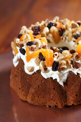 Christmas cake with raisins, almonds and other fruits and cream