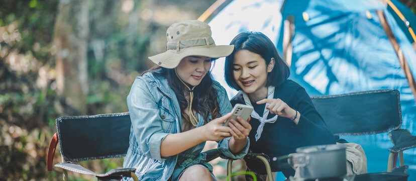 Asian Pretty Woman And Friend Use Smartphone Selfie On Camping