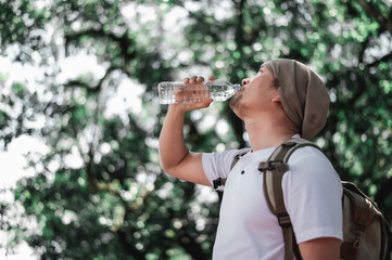 Portrait Asian traveler man with backpack drinking water