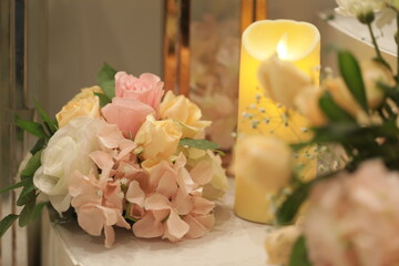 lovely lily and rose bouquet with a broad candle on the side