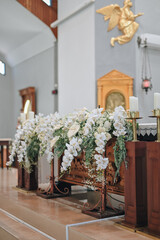Wedding decoration indoors. Cathedral, church decoration for ceremonial wedding. Grooms and Bride