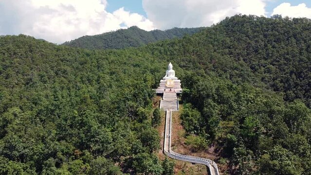 Aerial: Circeling around the big white Buddha in the middle of the mountain in Pai, Thailand.
