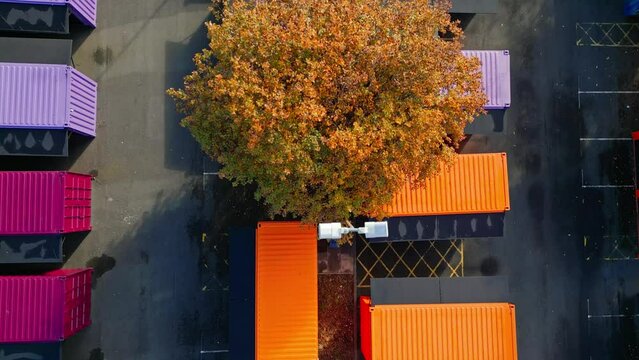 Aerial Footage Of Multicolored Porta Cabins, Market Stalls, Steel Cabins, Storage Units, Shot From Directly Above And Moving Slowly Backwards.