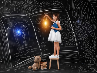 Cute little girl with lantern near drawn big magic book on dark background