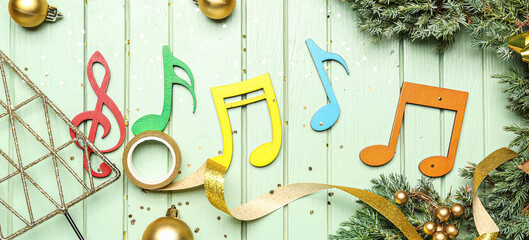 Composition with music notes and Christmas decor on green wooden background
