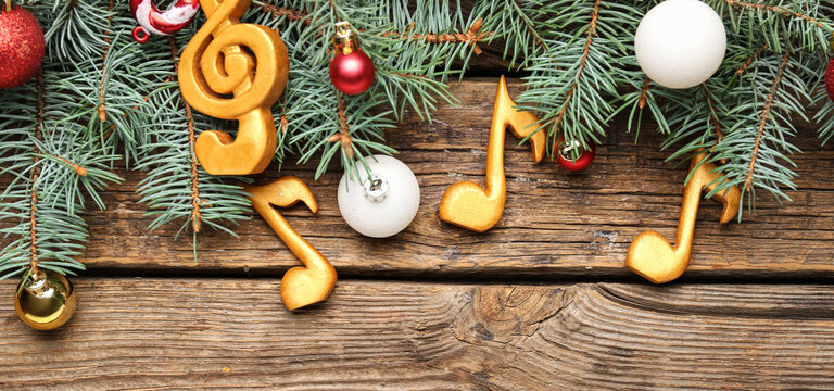 Composition with music notes and Christmas decor on wooden background