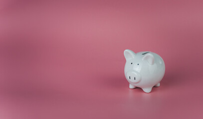 white piggy bank on a pink background. Savings and investment concepts.