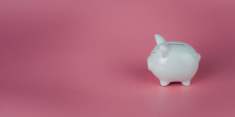 white piggy bank on a pink background. Savings and investment concepts.