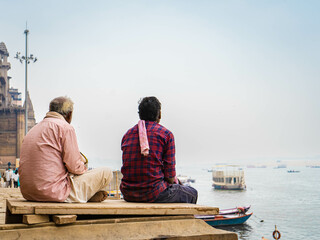 two men chatting in front of the river ganges in varanasi india