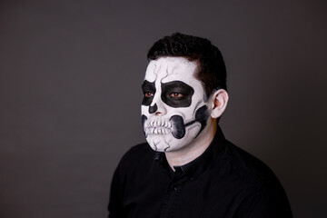 hombre maquillado de catrin o calavera para el dia de muertos como tradición mexicana con cara pintada con el concepto tradicional mexicano