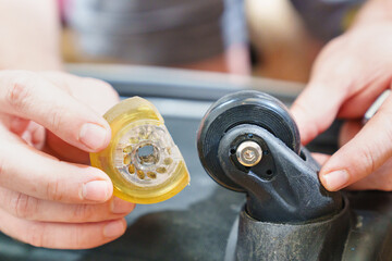 Fototapeta premium replacing the old erased wheel on the suitcase with a new one. the concept of reasonable consumption and repair of old things. repairman's job.