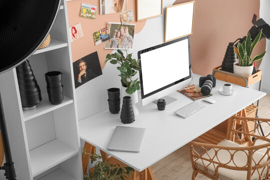 Photographer's workplace with computer and equipment in stylish office