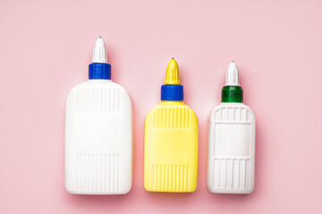 Bottles of glue on pink background