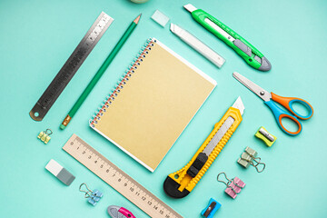 Utility knife with stationery on blue background