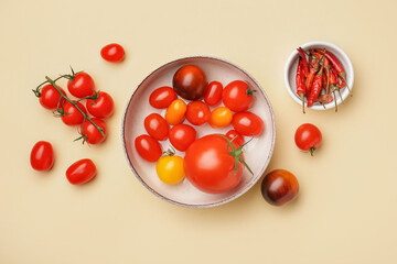 Bowl with different fresh tomatoes on color background