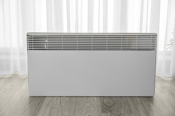 Radiator near light curtain in room. Heating season concept
