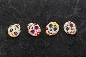 Tasty skull shaped cookies on black background. El Dia de Muertos