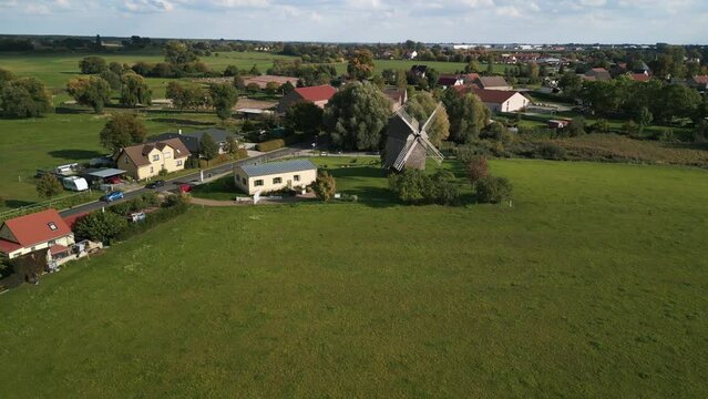 Calm aerial view flight speed ramp Hyperlapse motionlapse timelapse
of a old Wooden Trestle windmill in brandenburg Germany at summer golden hour 2022. 4k marnitz Cinematic